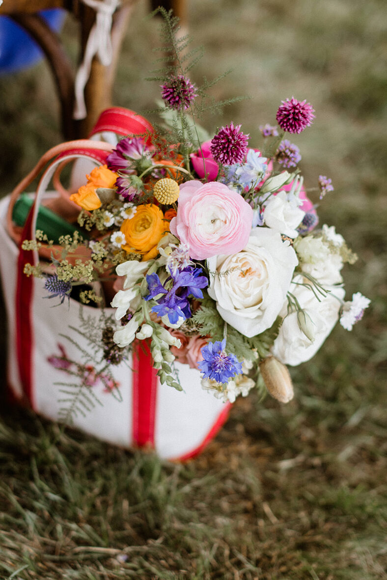 colorful summer flowers stick out of a cute white bag 