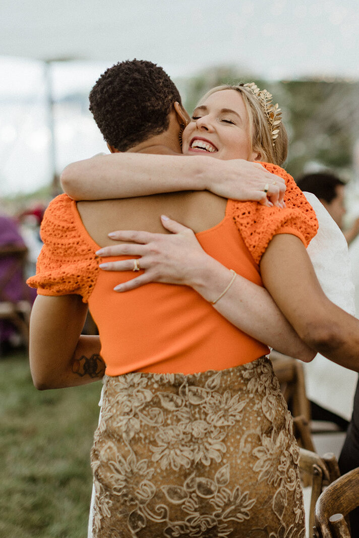 bride shares a hug with a guests 