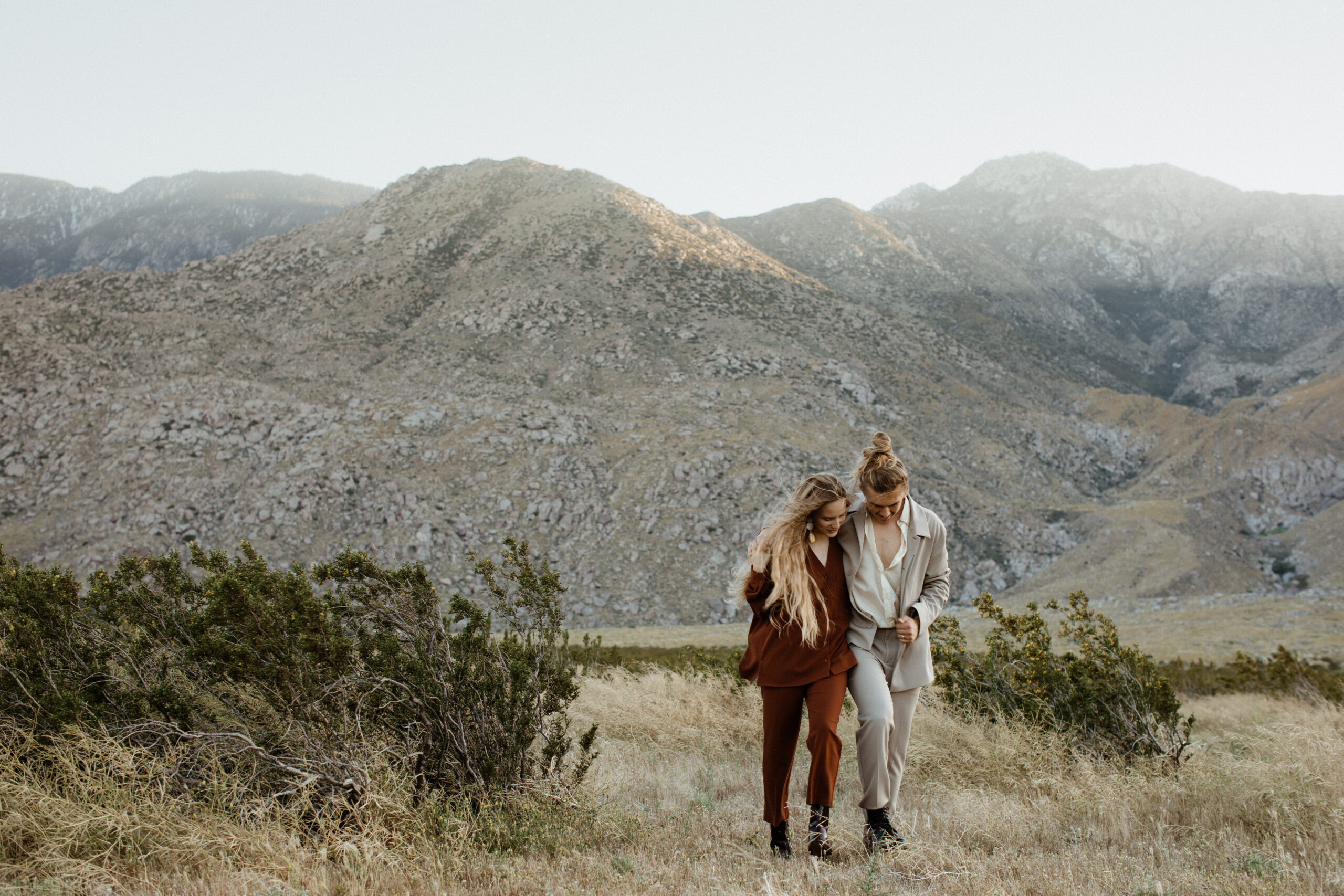 couple pose together in front of the mountains during their dreamy engagement photos in palm springs