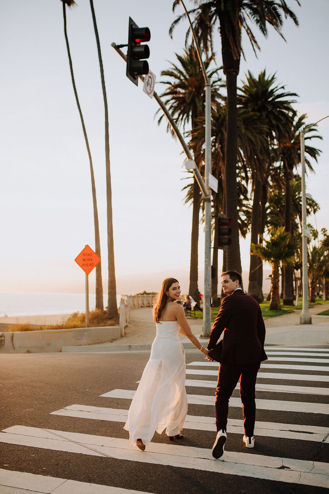 stunning couple walk together with the beautiful West Coast sunset in the background
