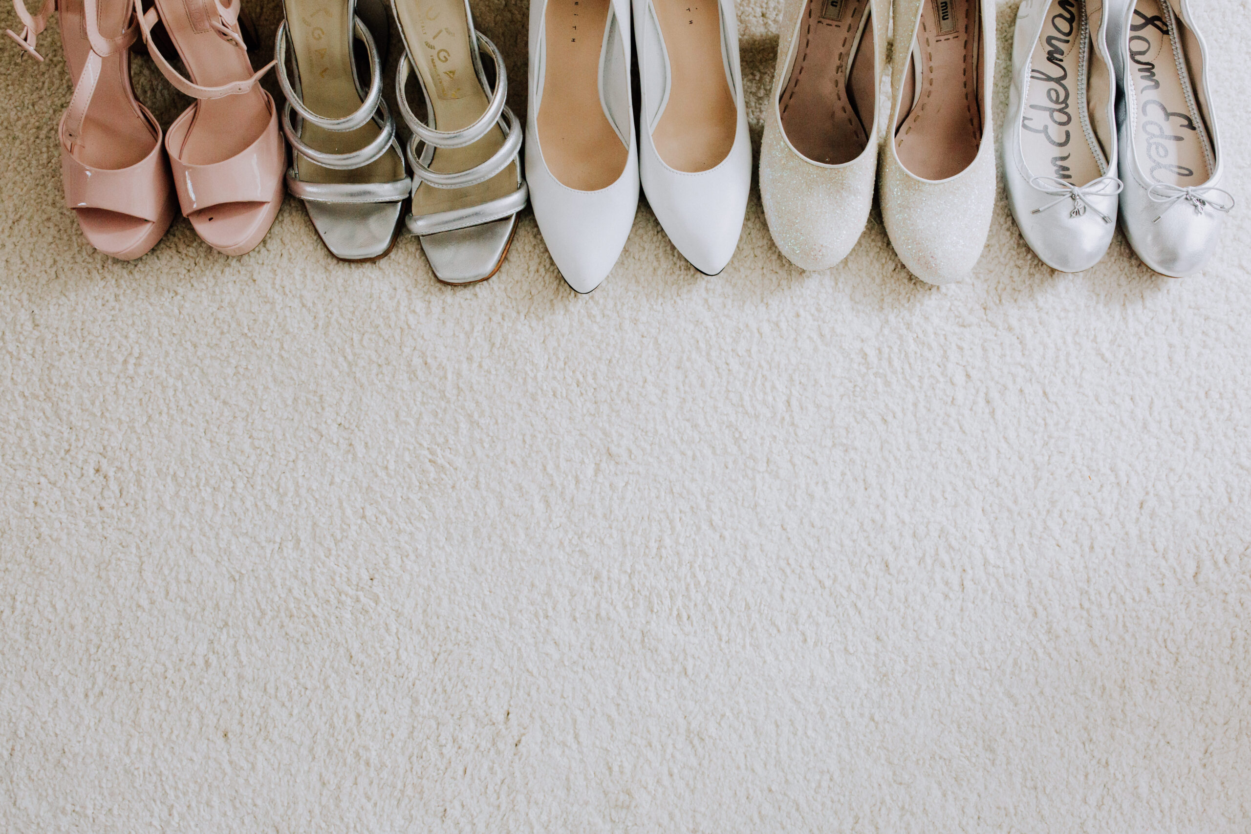 brides shoes sit with the bridesmaids shoes before the wedding ceremony 