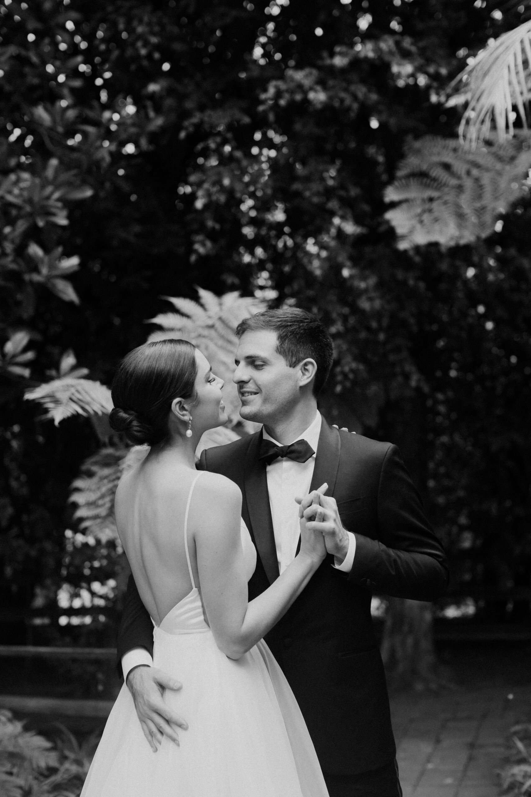 bride and groom pose together in a lush garden