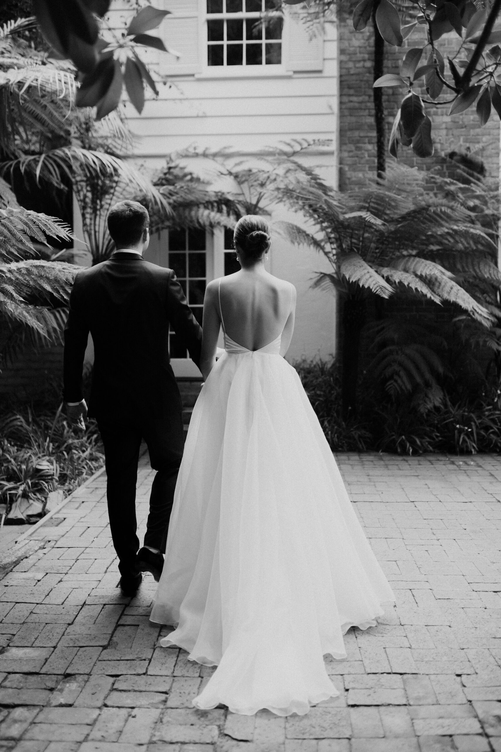 bride and groom walk together toward their backyard Los Angeles wedding ceremony 