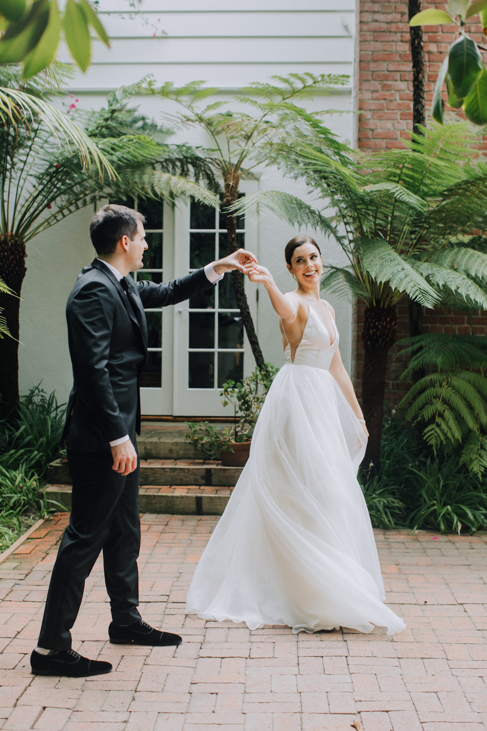 bride and groom pose together in a lush garden