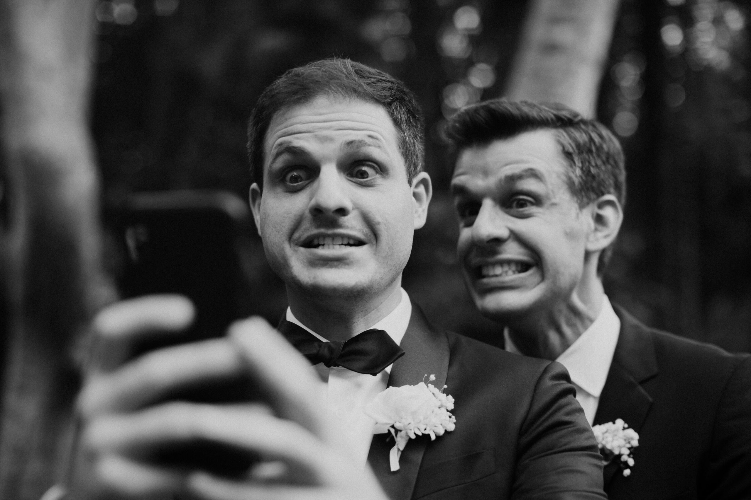 groom takes a funny selfie with a groomsmen 