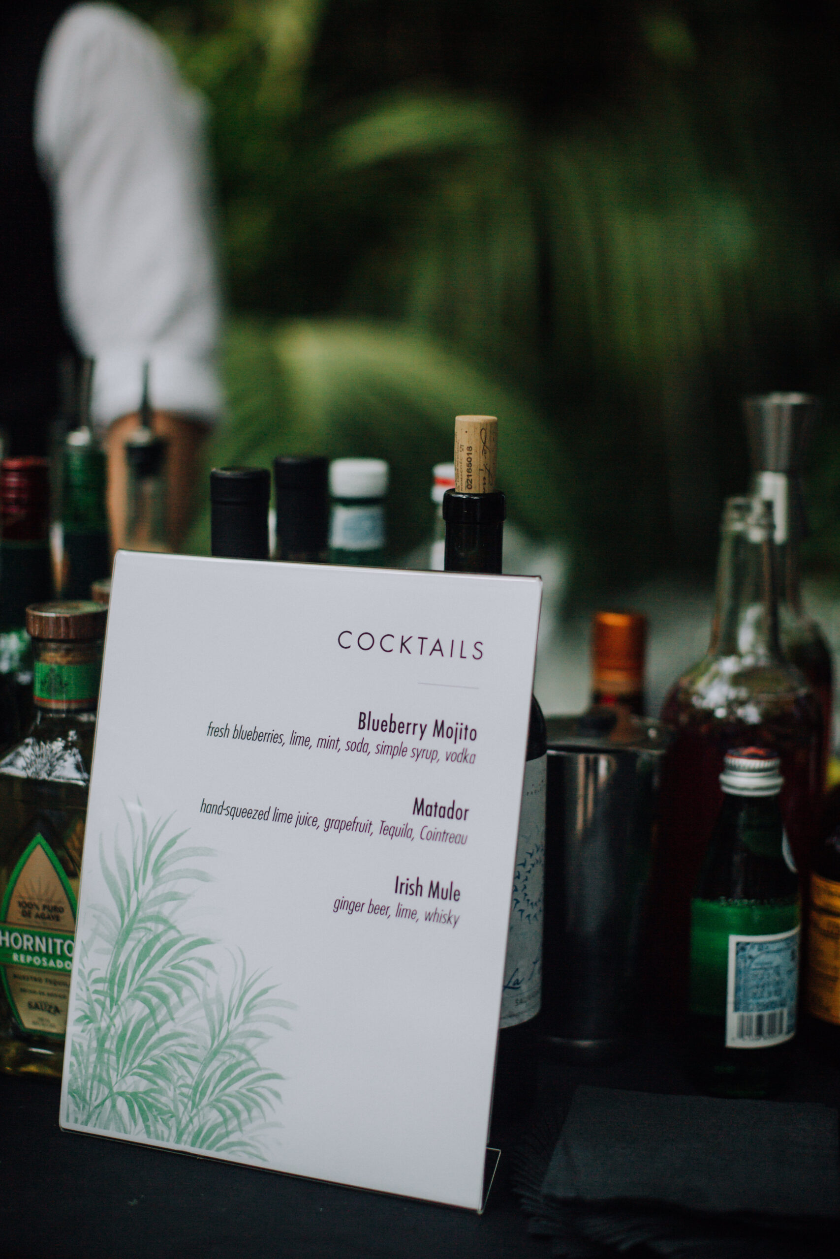cocktail hour menu with the bottles in the background