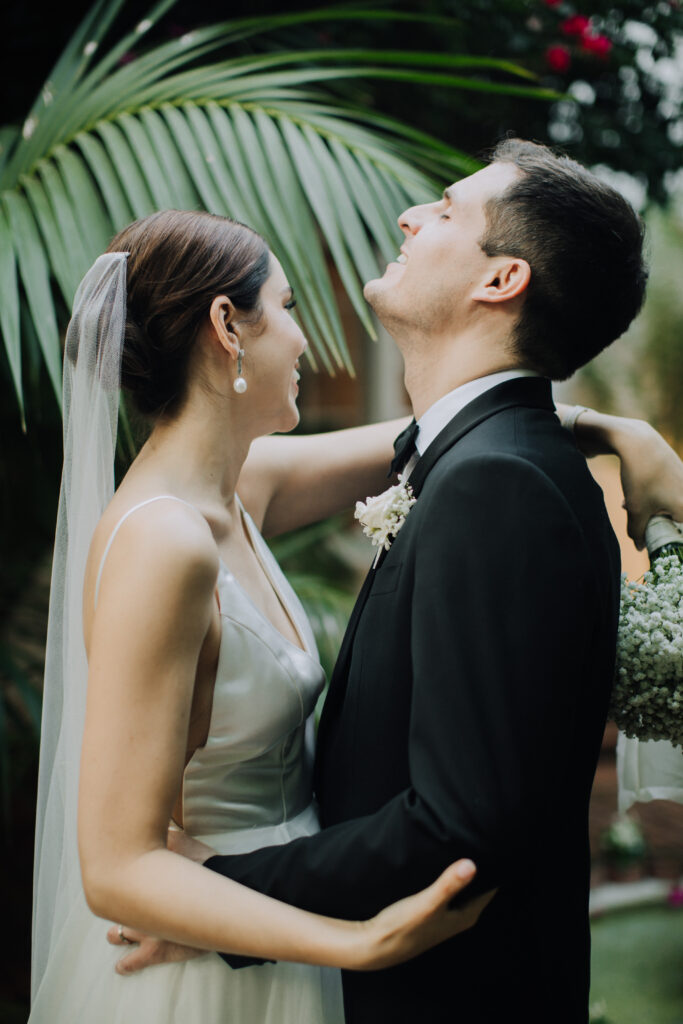bride and groom pose together in the lush backyard garden 
