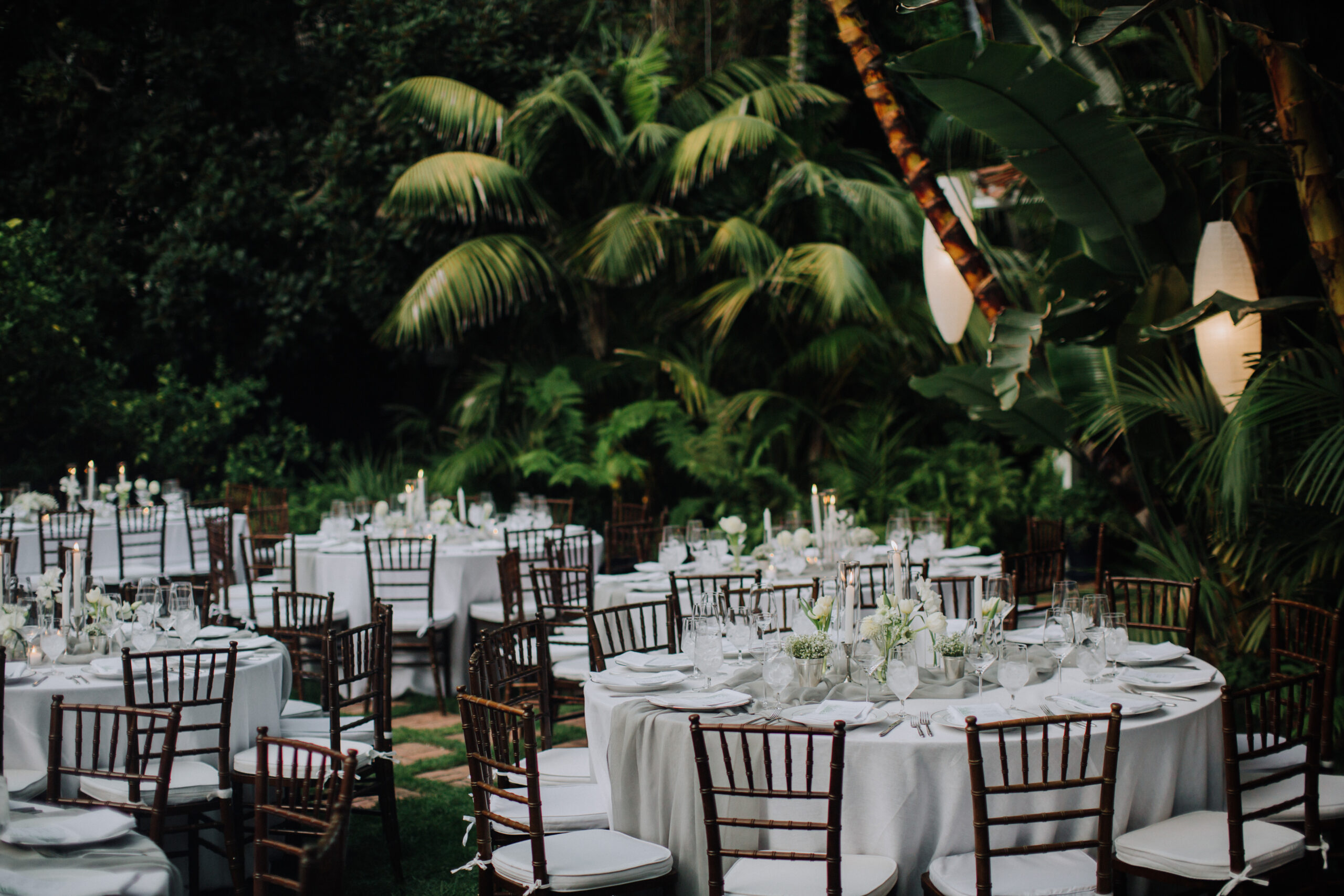 wedding reception sits in the lush garden ready for the guests
