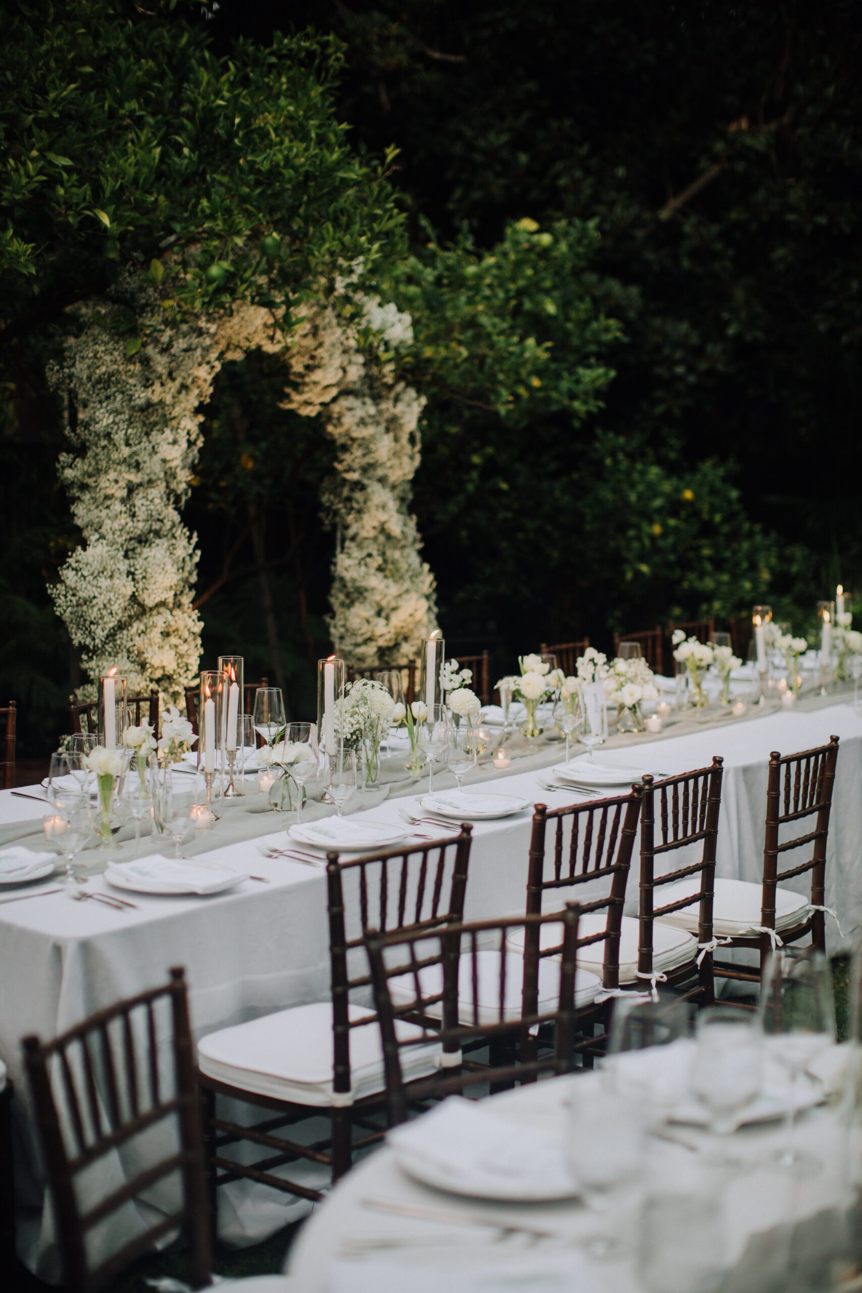 wedding reception sits in the lush garden ready for the guests