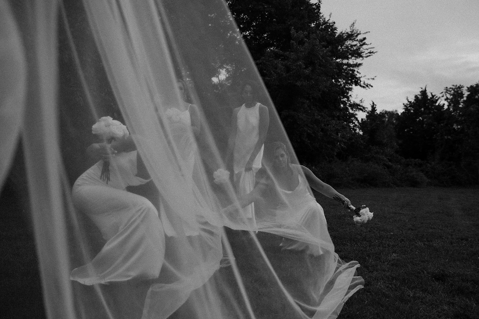 bridal party poses together through the brides veil