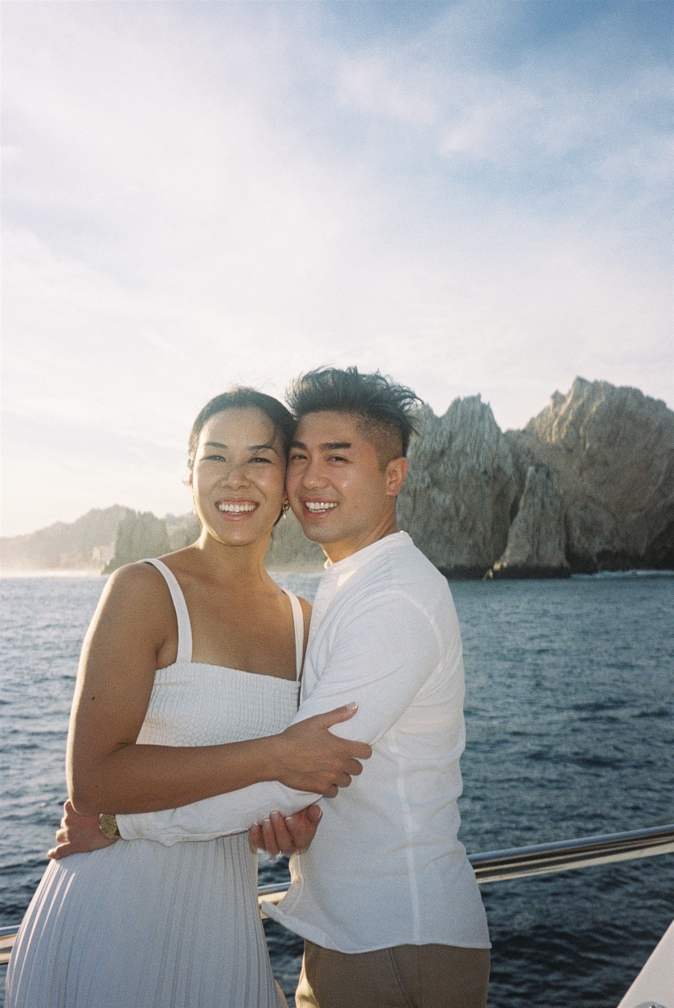 bride and groom pose together on a boat before their dreamy acre baja wedding day