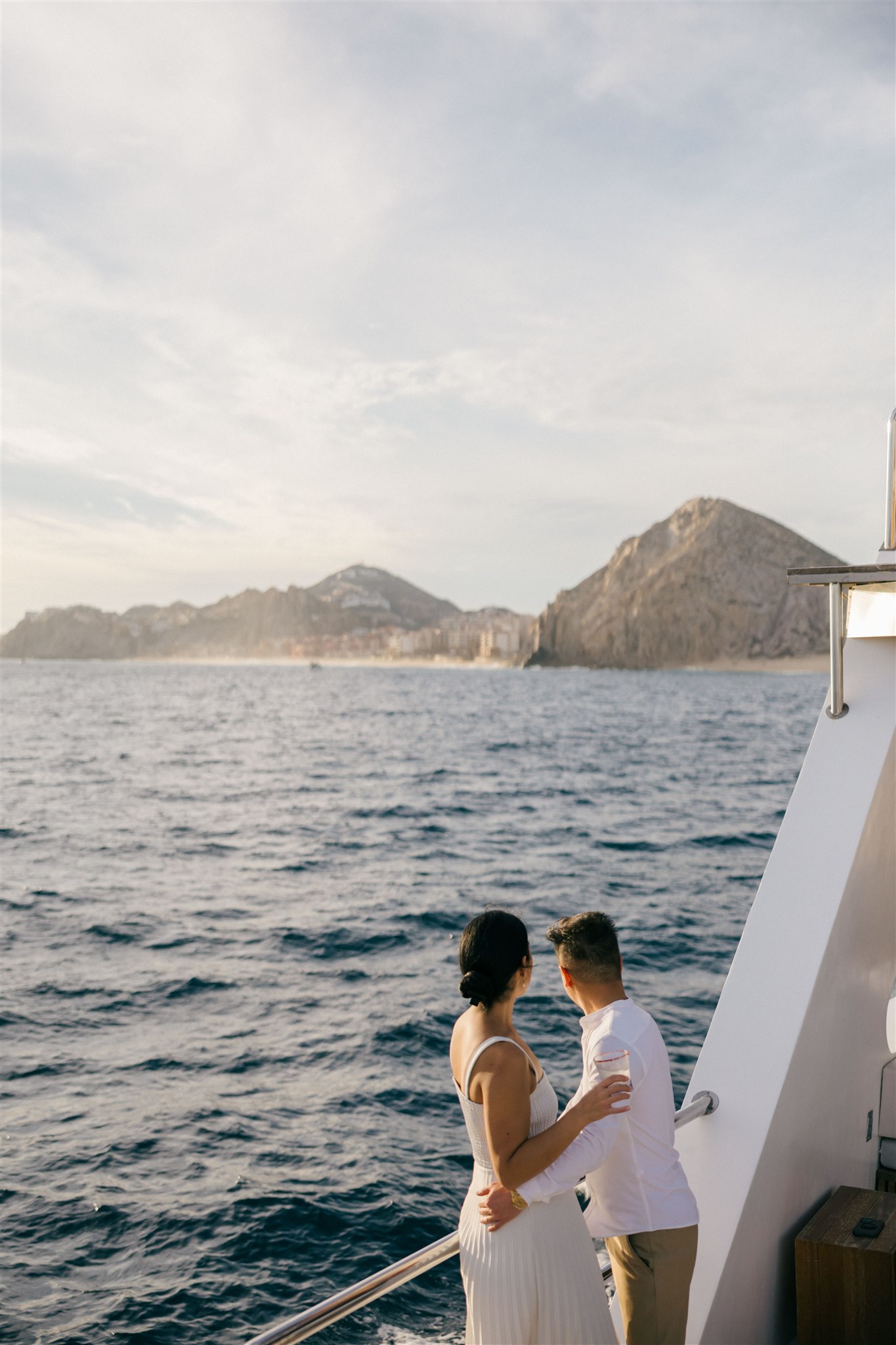 bride and groom pose on a boat together