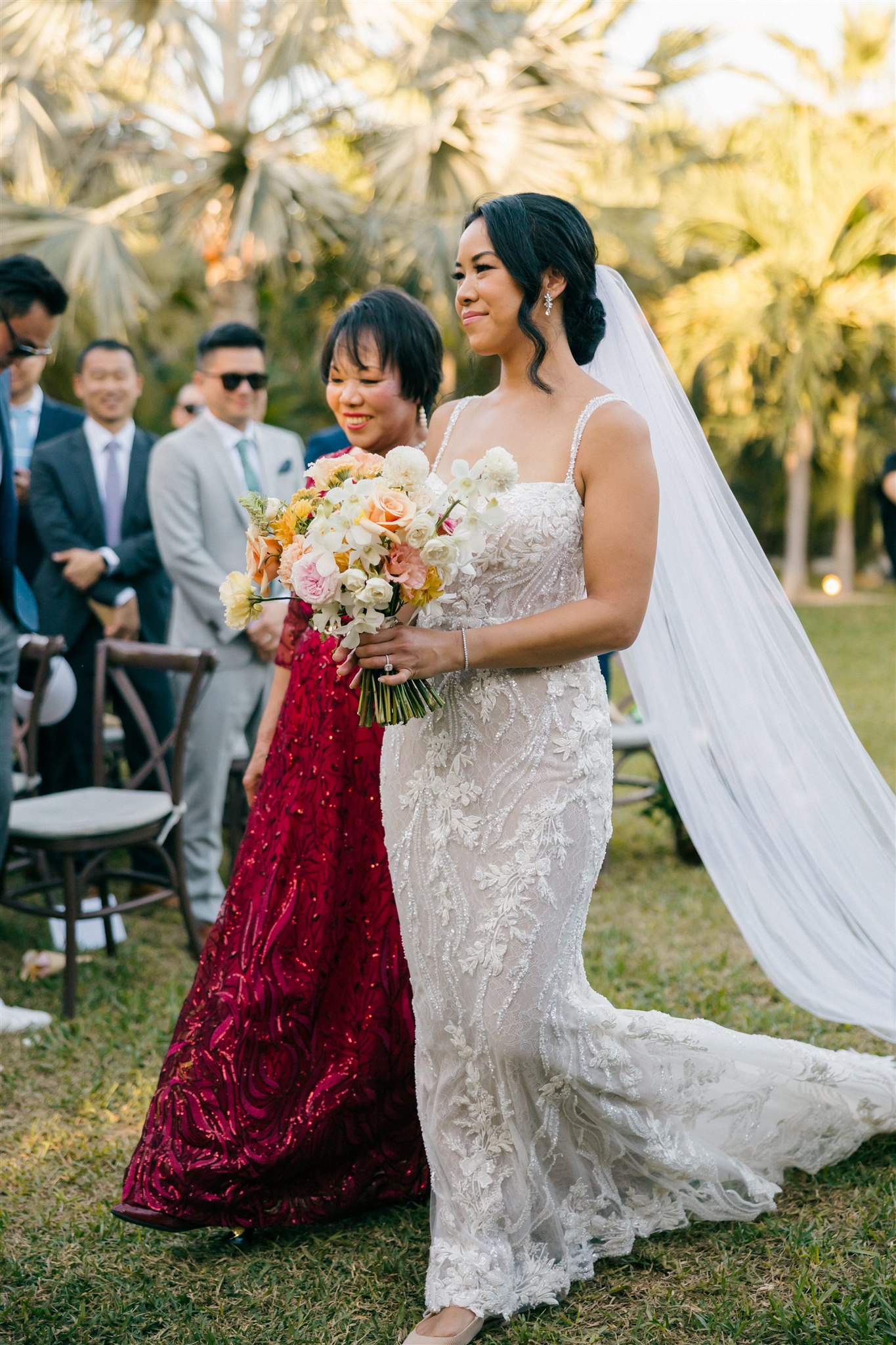 bride walks down the aisle with her mother 