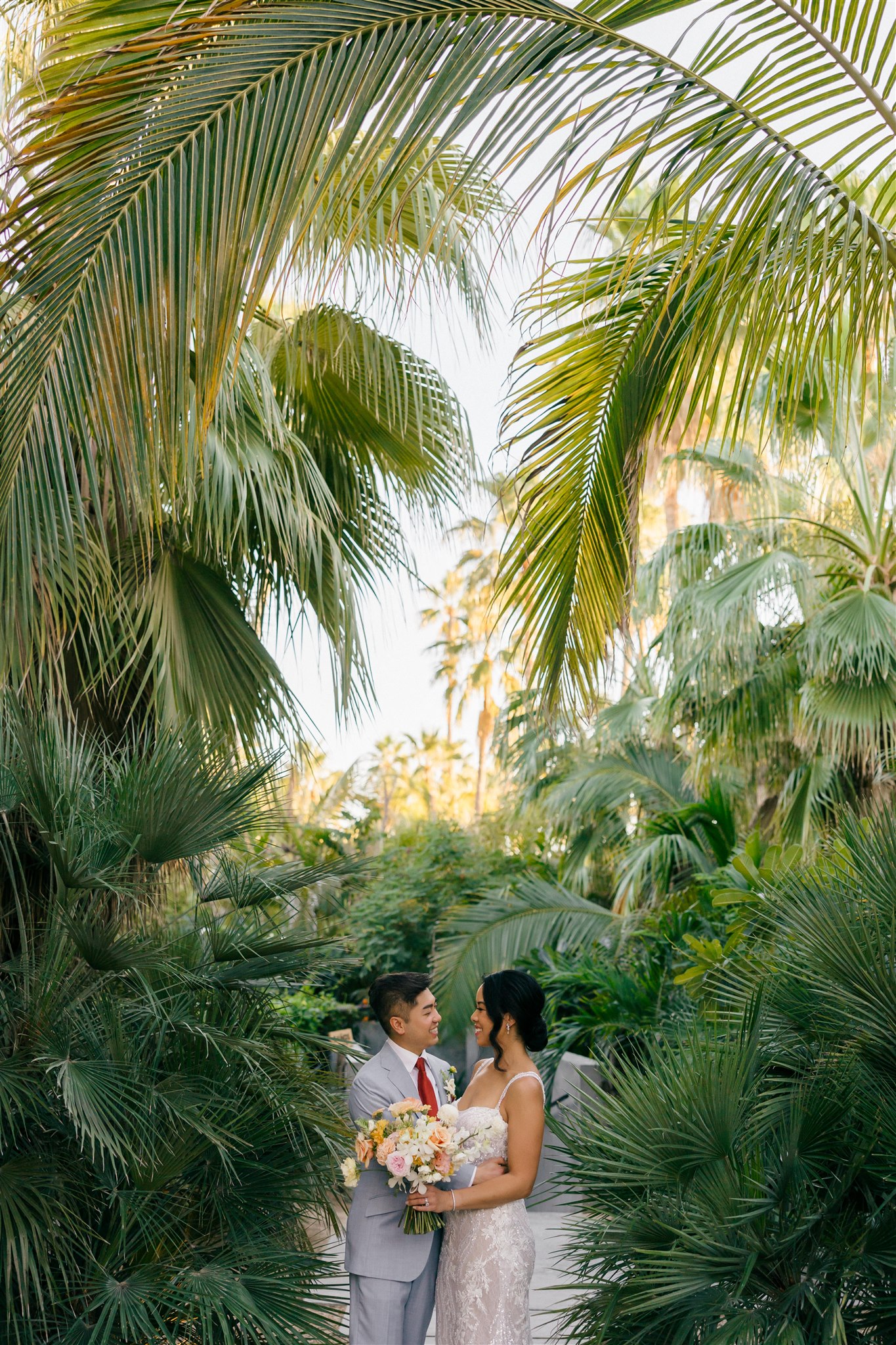 bride and groom pose in the tropical acre baja wedding venue