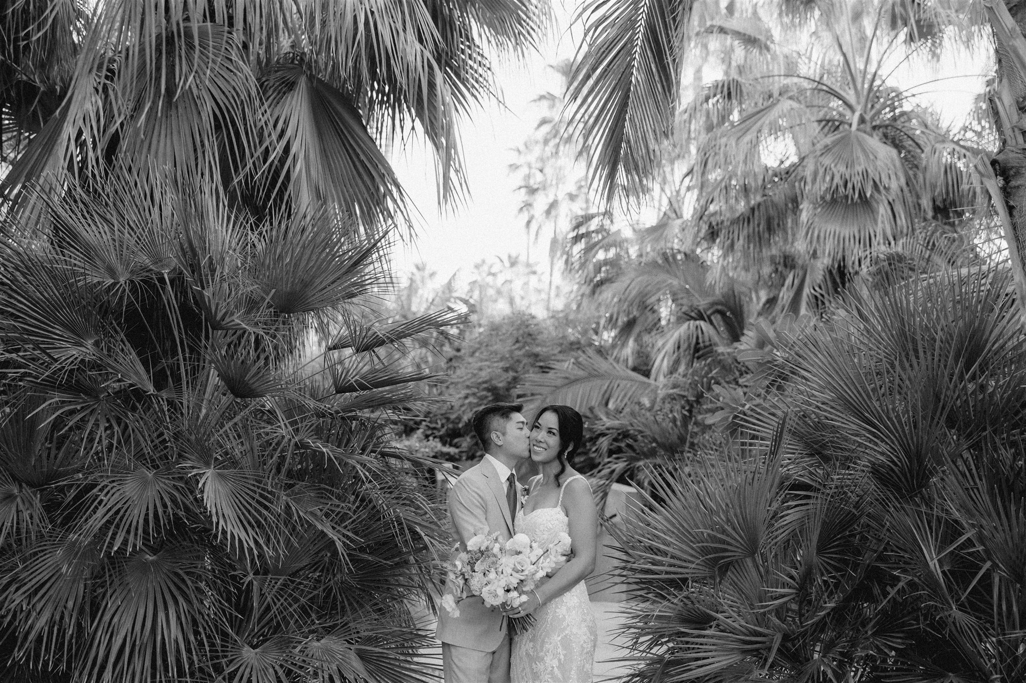 bride and groom pose in the tropical acre baja wedding venue