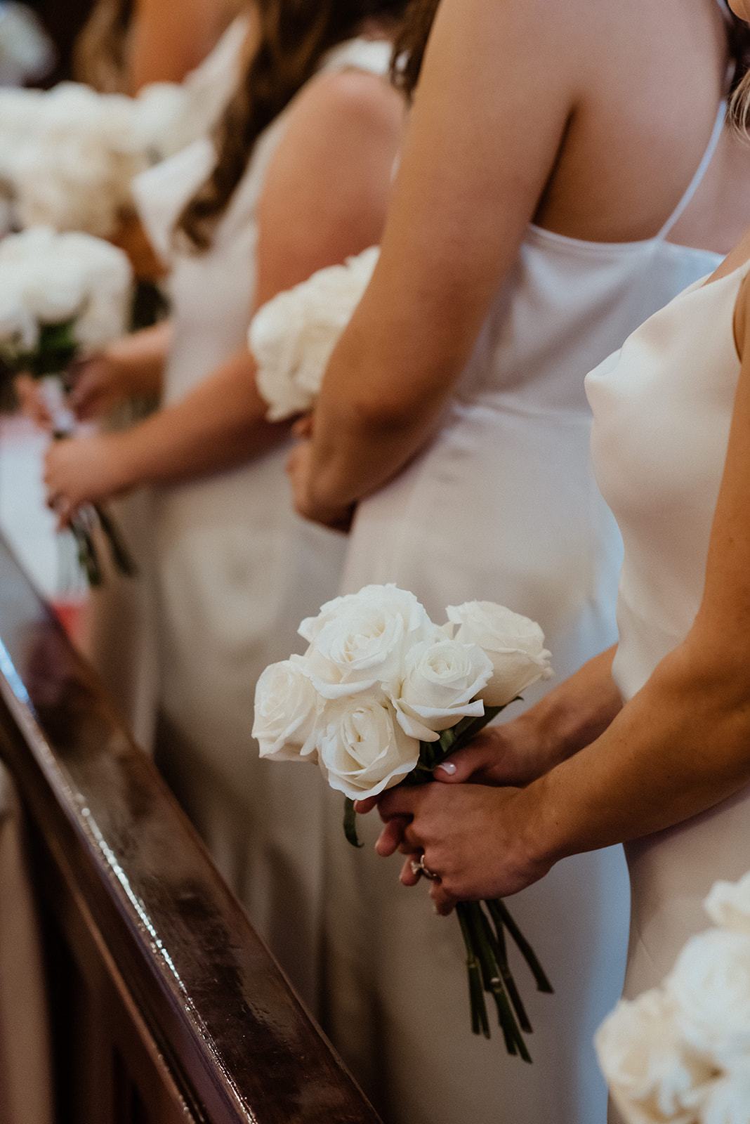 bridal party holds their white wedding flowers