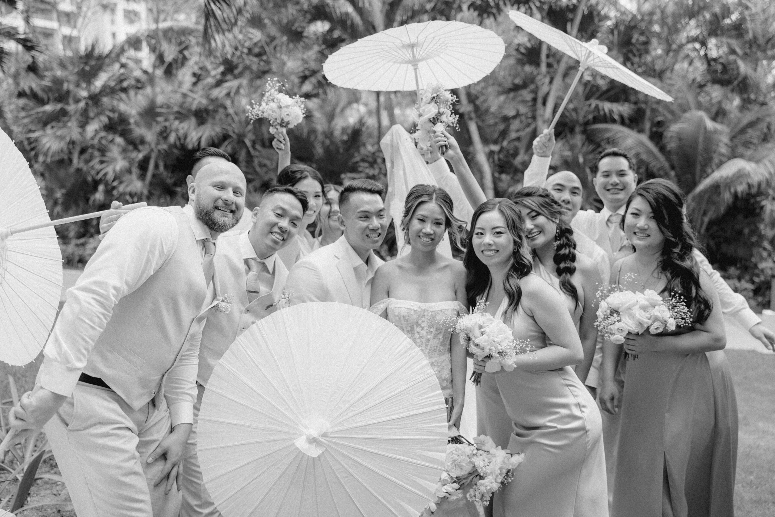 wedding party poses together with umbrellas