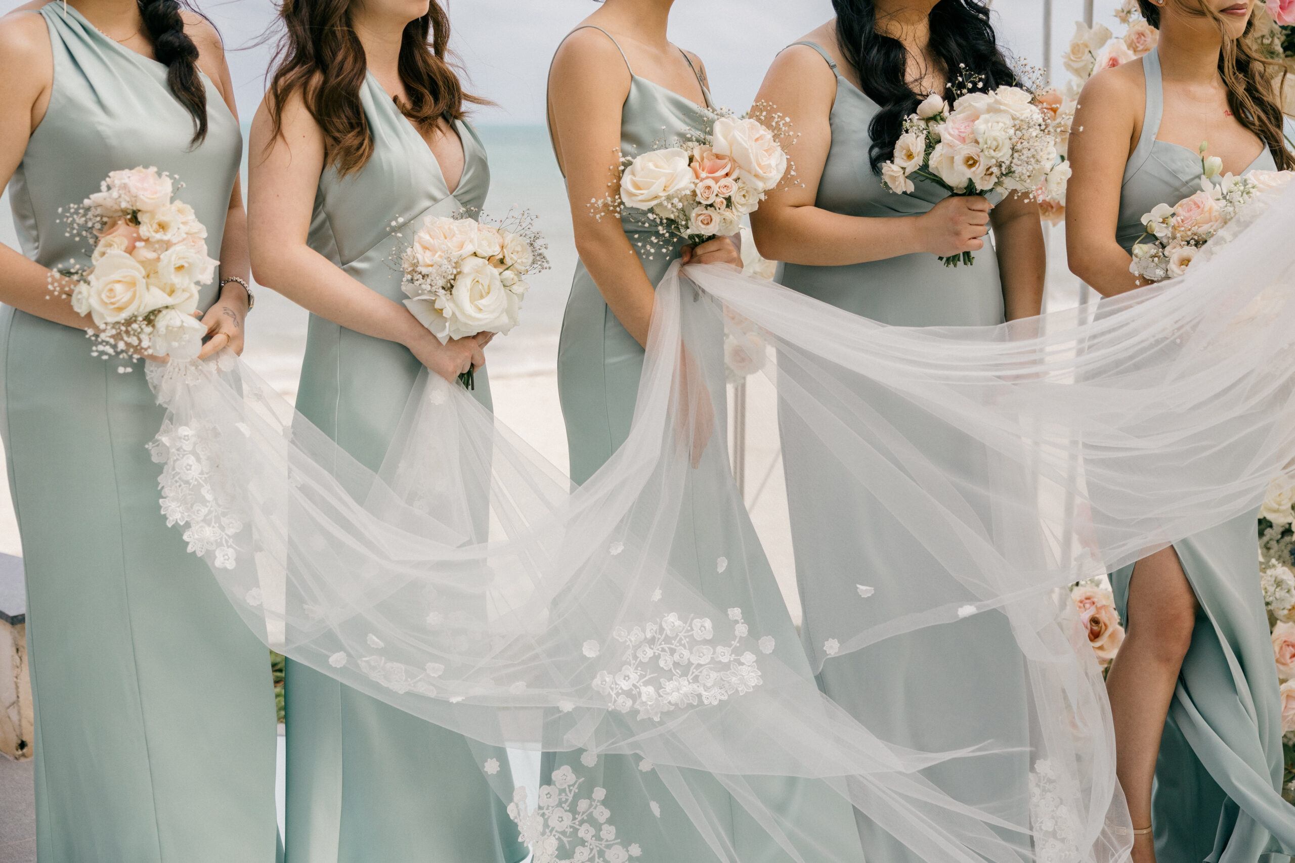 bridesmaids pose on the beach 