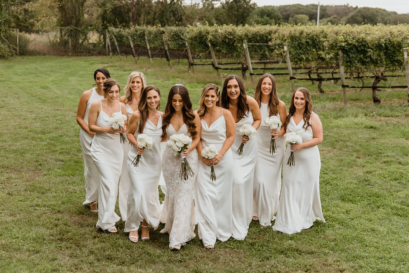 bridesmaids pose with the bride on the stunning vineyard grounds