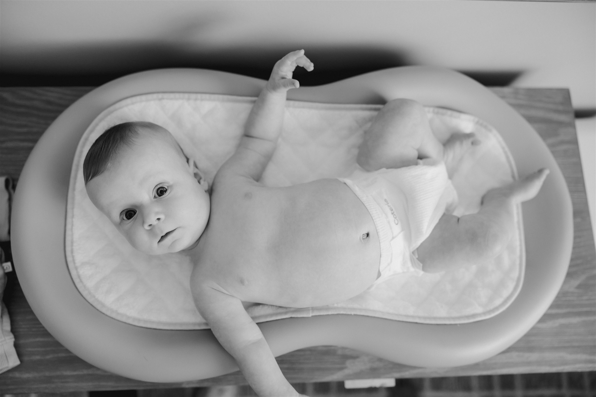 beautiful newborn lies in crib during a candid in-home newborn sessions