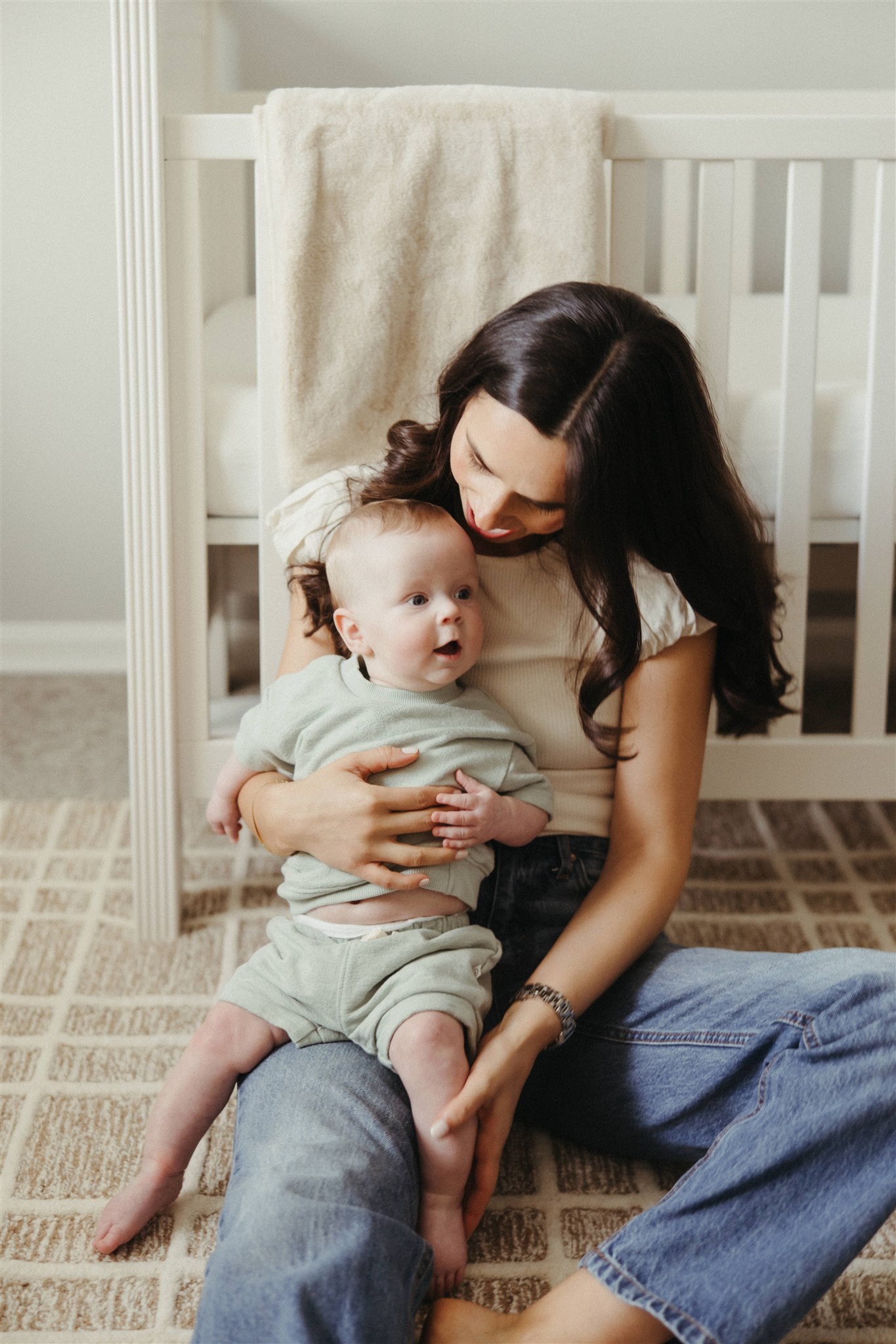 new mom poses with her newborn during their in-home newborn sessions