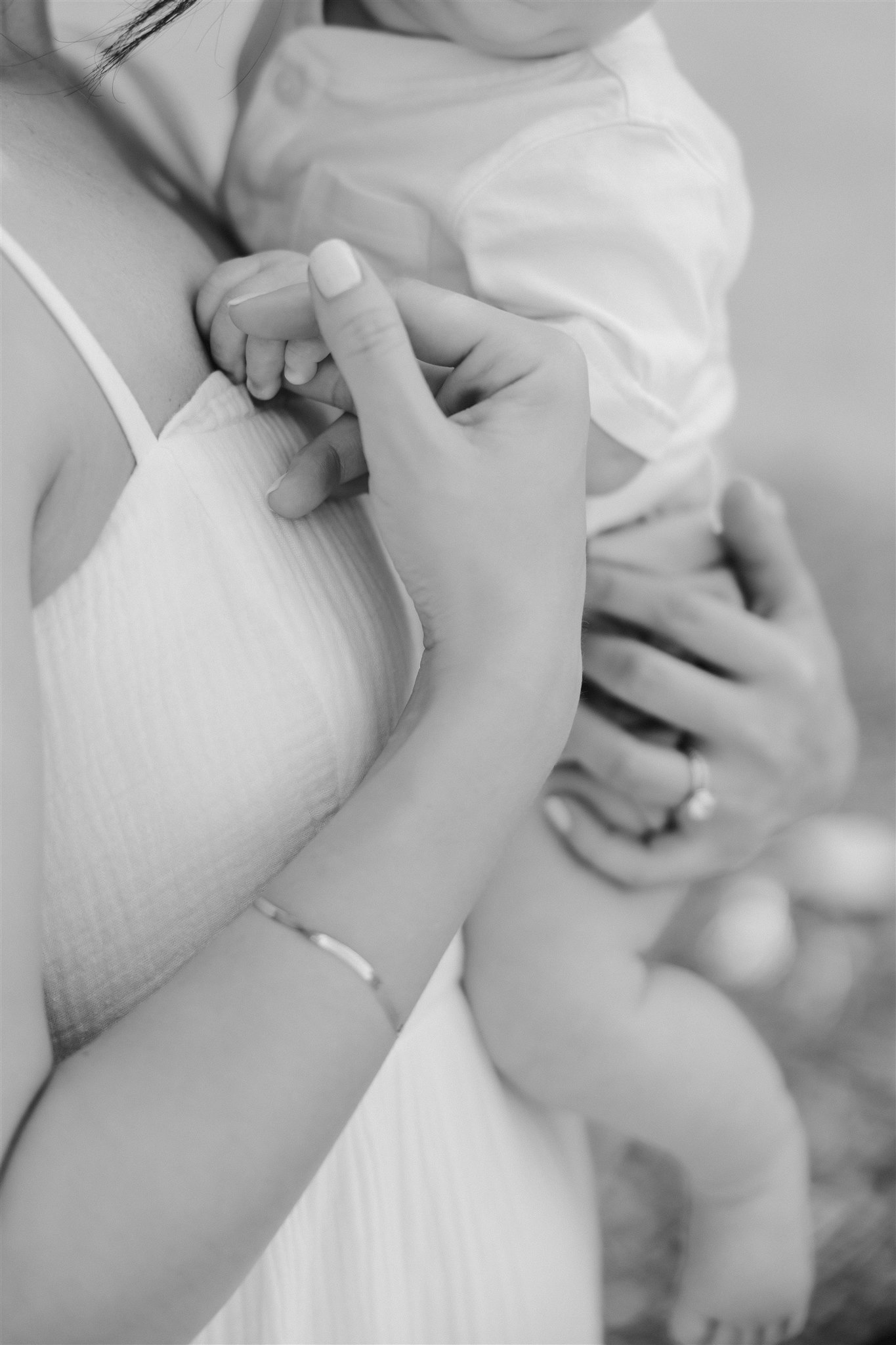 new mom poses with her newborn during their in home family photo session