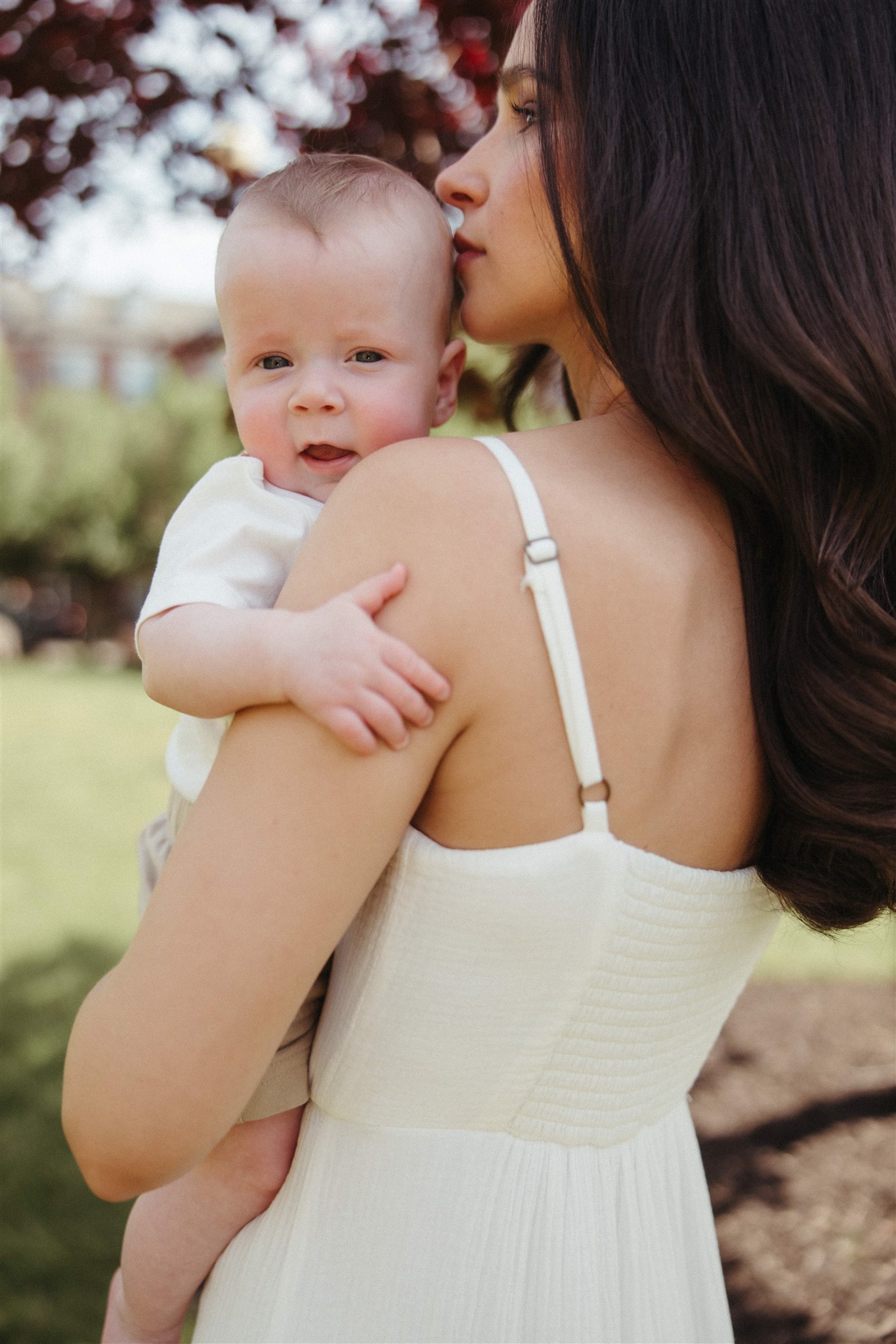 new mom poses with her newborn during their in home family photo session