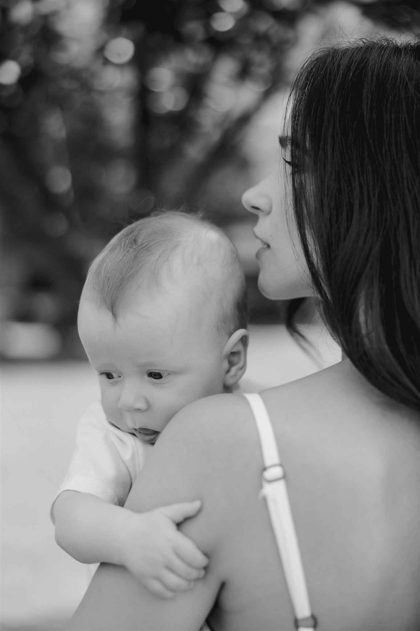 new mom poses with her newborn during their in home family photo session