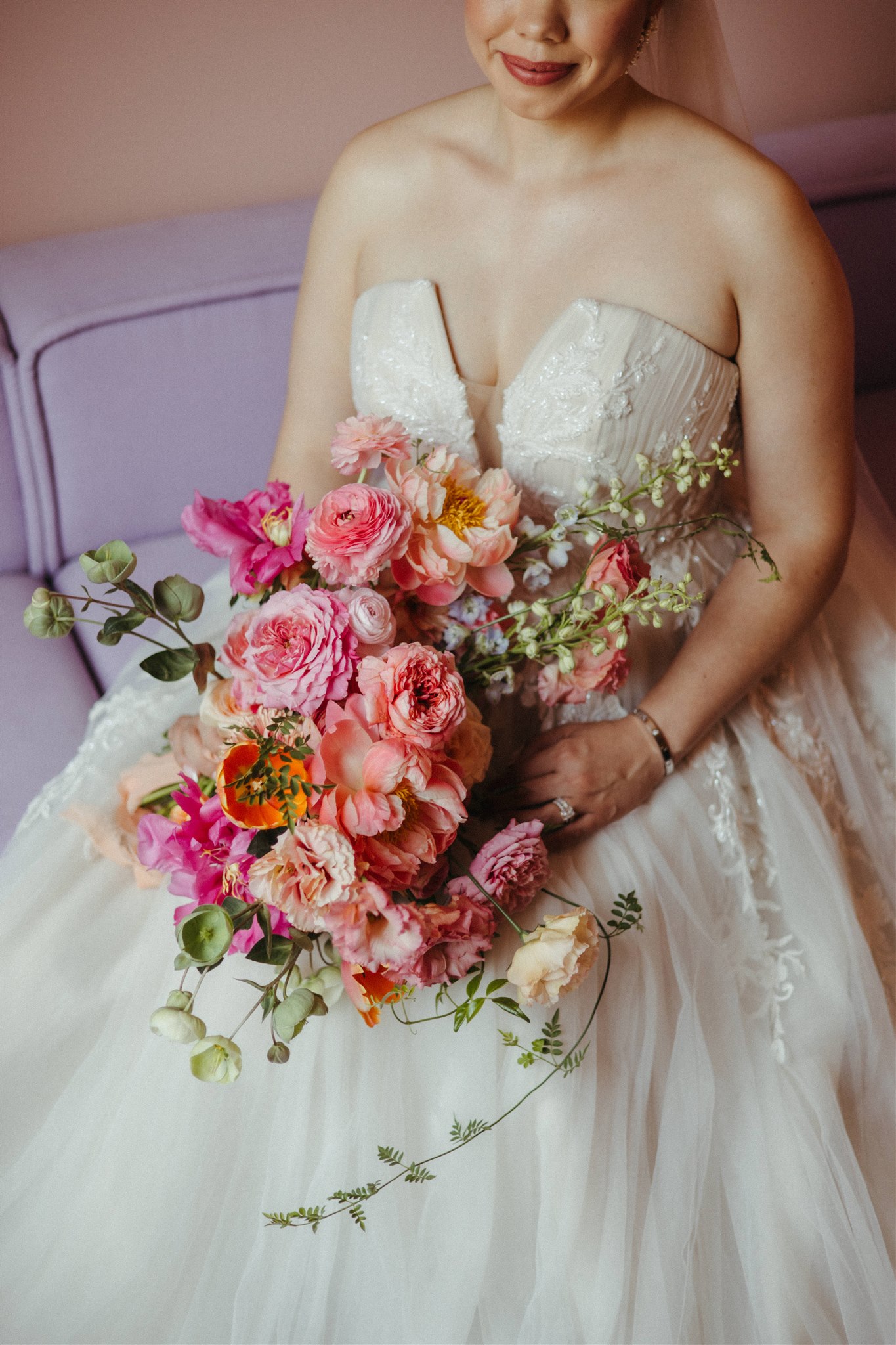 Detail shot of wedding dress against bold Ignacia Guest House orange wall